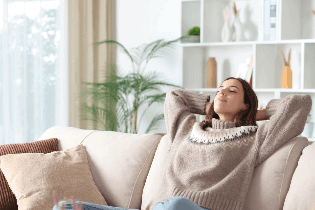 Frau liegt glücklich auf ihrer Couch